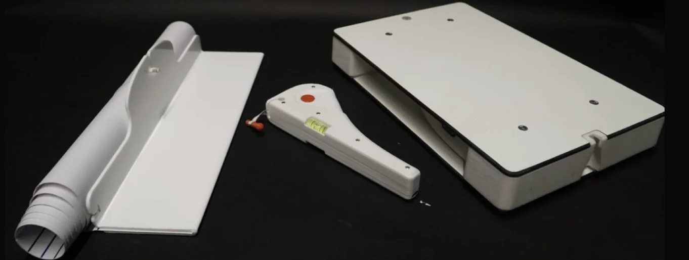 Prototype of the infant measuring mat, handheld measuring device and weighing scale arranged on a dark surface